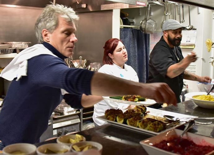 Jon Bon Jovi serves food alongside volunteers in the kitchen at JBJ Soul Kitchen, a nonprofit community restaurant helping fight hunger.
