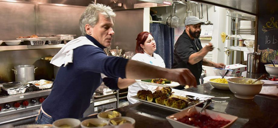 Jon Bon Jovi serves food alongside volunteers in the kitchen at JBJ Soul Kitchen, a nonprofit community restaurant helping fight hunger.