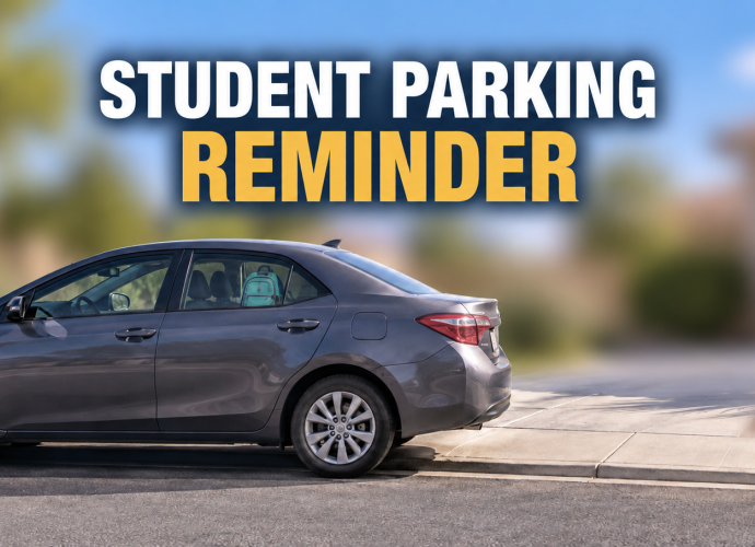 Gray sedan parked near a residential driveway with the words “Student Parking Reminder”