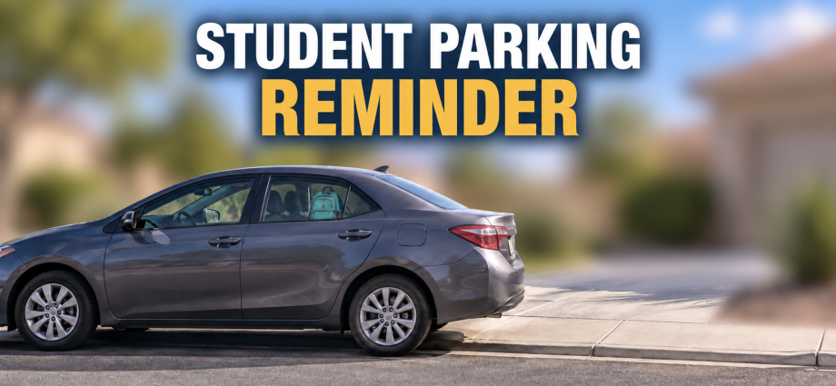 Gray sedan parked near a residential driveway with the words “Student Parking Reminder”